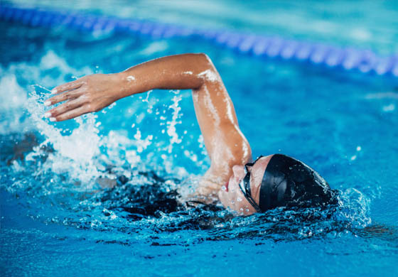 Young, strong woman doing the front stroke in a pool