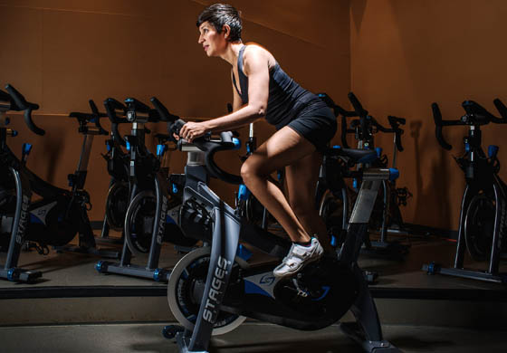 Woman riding a Stages stationary bike in our Cycling Studio at the Toronto Athletic Club.
