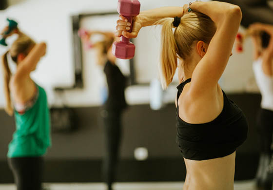 Women using dumbbells in a group fitness class.