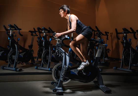 Woman on a Stages stationary bike in the Cycling Studio at the Toronto Athletic Club