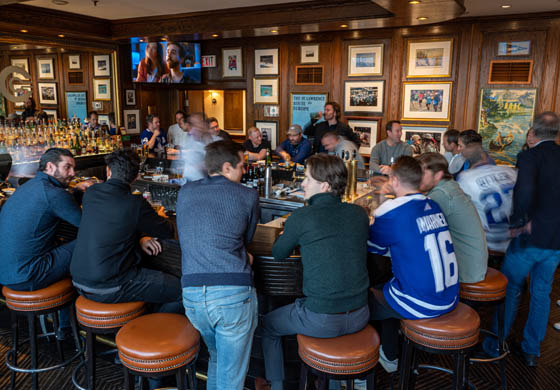 Crowded bar of members and guests in the Oak Room at the Cambridge Club