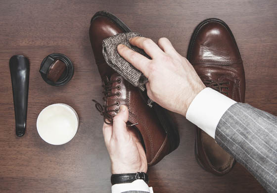 Close-up of man's hands as he shines his brown shoes