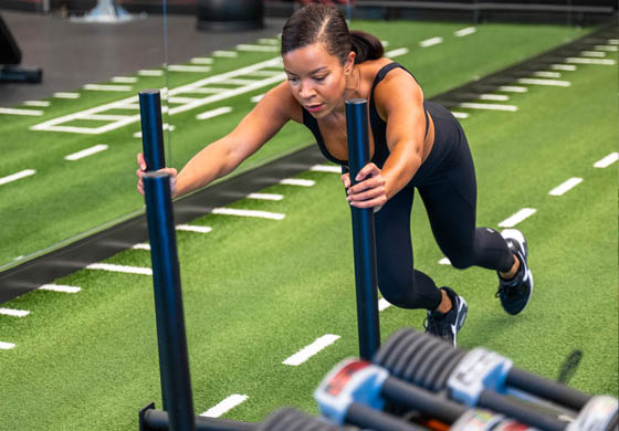 Isabelle, our Membership Advisor, doing a sled push on the turf in the Strength Lab at the Toronto Athletic Club