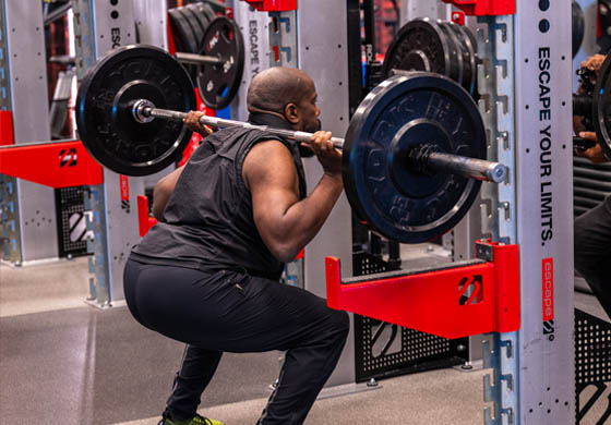 Strong black man doing a squat in the Strength Lab at the Toronto Athletic Club