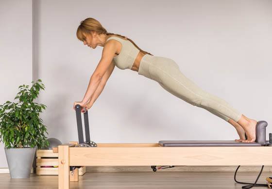 Young woman doing a Pilates workout on a reformer